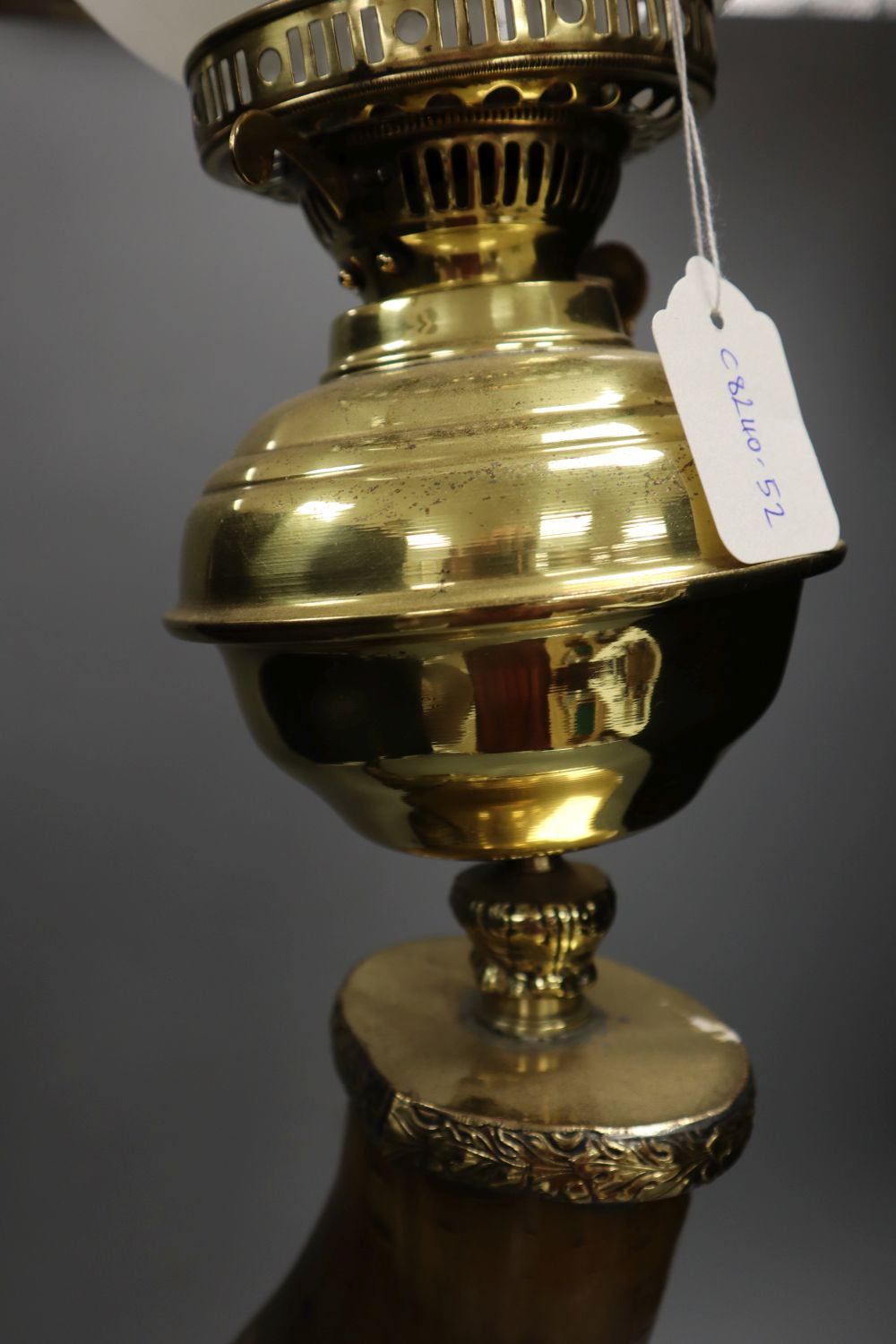 A brass oil lamp, with horn stem, 23in.